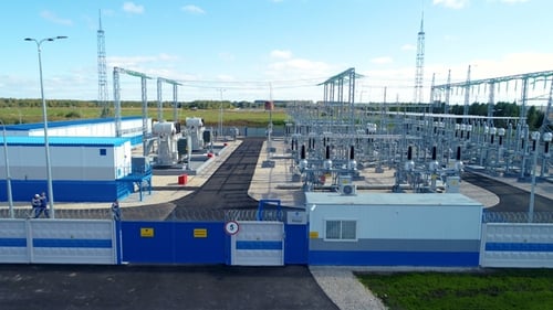 Los trabajadores caminan por la estación eléctrica acercándose