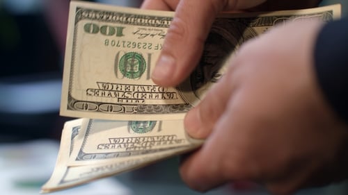 Close Up of Hands Counting Hundred Dollar Bills