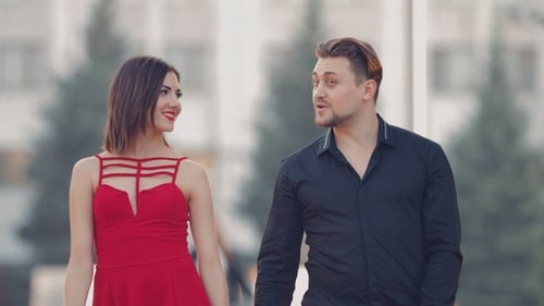 Young Guy with a Girl Goes for a Walk in the Summer Park