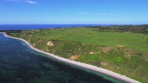Aerial View of Ocean Coastline and Green Hills