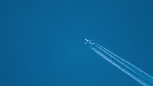 Commercial Airplane Flying Across Blue Sky
