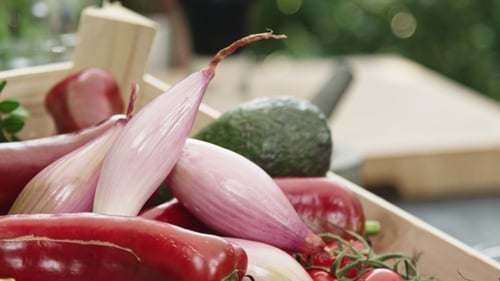 Fresh Vegetables in Wooden Crate with Hand Reaching