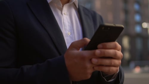 Male Chatting on Mobile on the Street