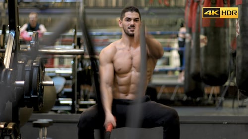 Muscular Man Exercising with Ropes in Gym