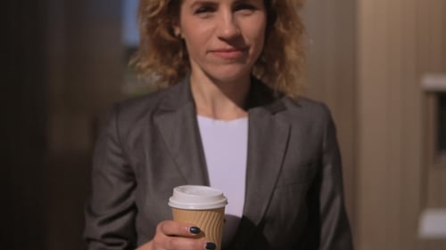 Confident Woman Walking with Coffee in City