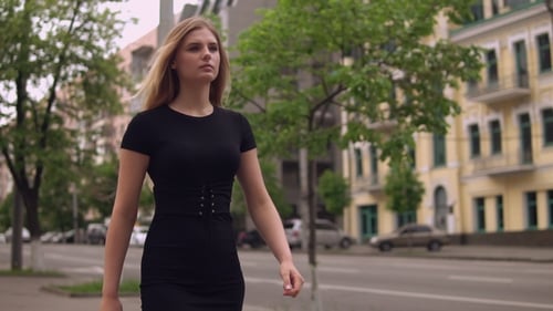 Young Woman Walks Down the City Street
