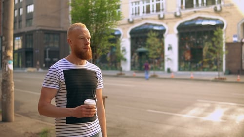 Man with Beard Walking with Coffee in City