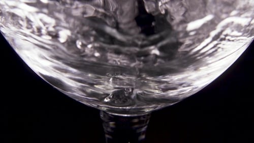 Pouring Clear Liquid into a Glass Close Up