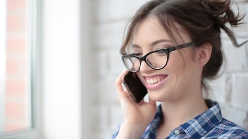 Portrait of a Happy Young Woman Speaking on a Cellphone