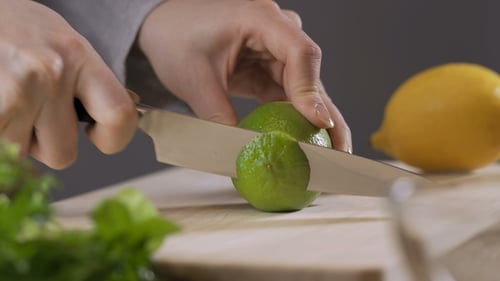 Woman Slices a Lime with a Knife