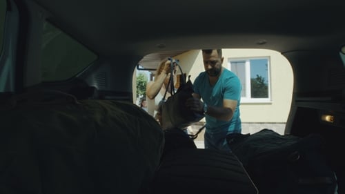 Family Packing Bags in Car Trunk