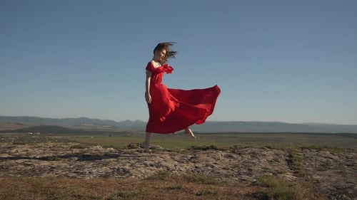 Woman in Red Dress Dancing on Hilltop