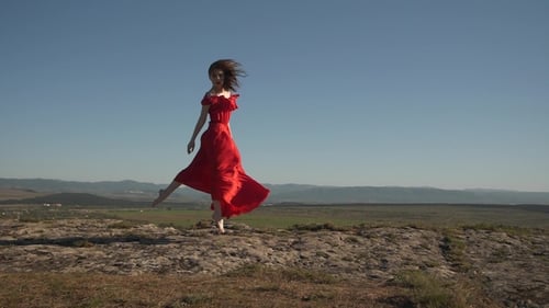 Woman in Red Dress Dancing on Hilltop