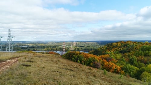 Türme der Hochspannungs-Verteilerleitung vor bunter Landschaft