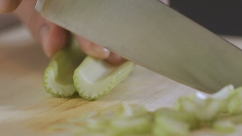 Man Is Cutting a Celery in the Kitchen