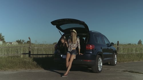 Woman and Child Relaxing in Car Trunk