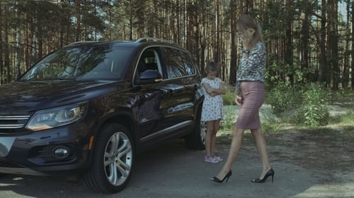 Woman On Phone With Child Near Car