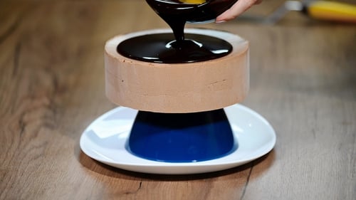 Glaze Chocolate Cake. The Confectioner Glazes a Cake and Garnishes It with Gold.