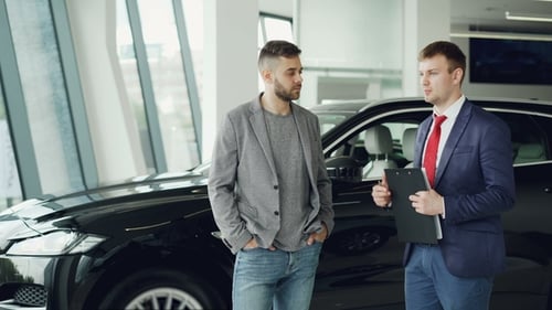 Guy Is Talking To Car Dealership Manager in Motor Show Discussing New Automobile Model