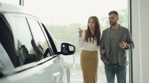 Young Couple Confident Bearded Guy and His Girlfriend Are Choosing New Automobile