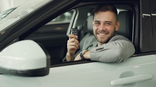 Happy Man Holding Car Keys in New Vehicle