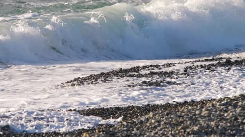 Meereswellen rollen auf den Kiesstrand