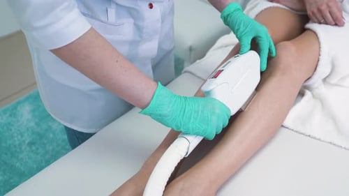 Dermatologist Does Leg Laser Epilation Procedure in Clinic