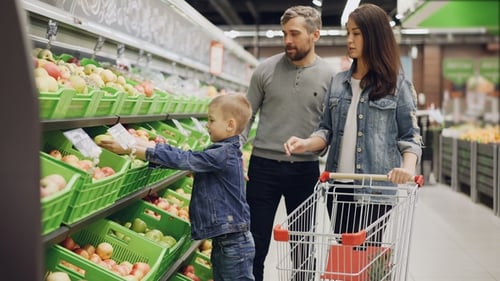 Young Family with Child Is Shopping for Food in Supermarket, Parents Are Choosing Fruit and Boy Is