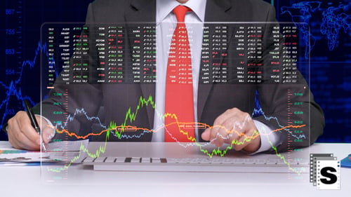 Man Analyzes Stock Market Data on Screen