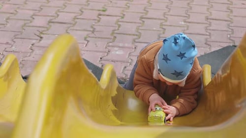 A Boy Rides His Car on a Hill in Autumn Weather