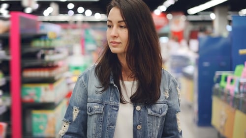 Woman Pushing Shopping Cart in Supermarket