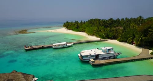 Wide angle flying clean view of a white sand paradise beach and blue ocean background in 4K
