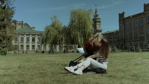 Two Female College Friends Meeting on Campus Lawn