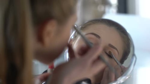 Hübsches Mädchen legt Lidschatten auf die Augenlider, Abend-Make-up, Date mit Geliebtem