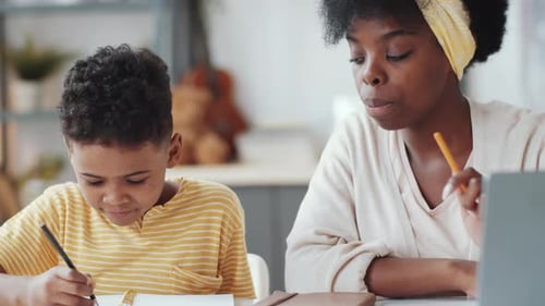 Woman Helping Child With Homework at Home