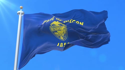 Realistic Waving Flag of Oregon Against a Clear Blue Sky