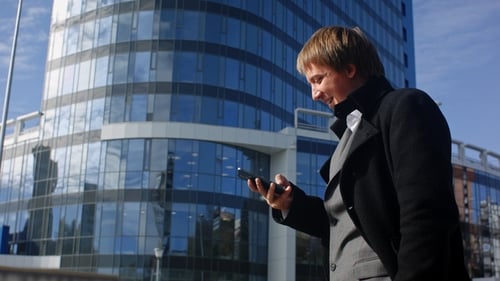 Successful Businessman Is Reading a Message on His Smartphone