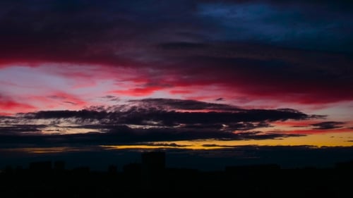 Bloody Red and Gold Sun Flare on Clouds. Evening Sunset