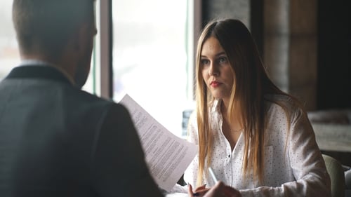 Businesswoman Interviewing Male Job Applicant In Office