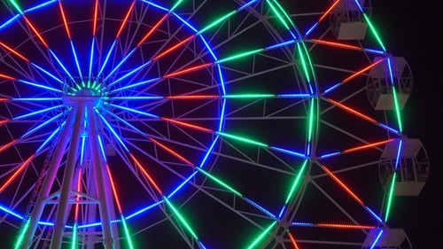 Illuminated Ferris Wheel Turning at Night