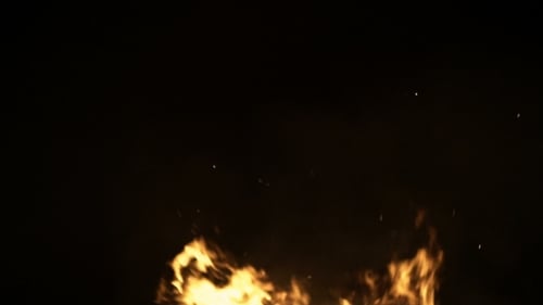 Burning Ash Rise From Large Fire in Black Background