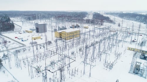 Hochspannungs-Umspannwerk verteilt Strom gegen Wälder