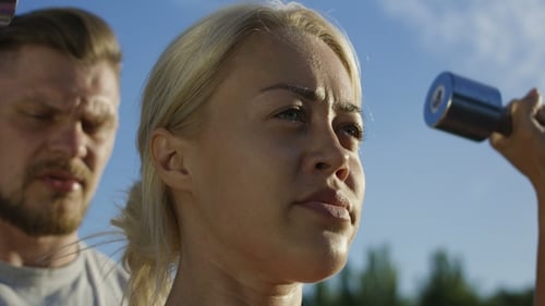 Woman Lifts Weights with Trainer Outdoors