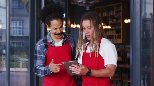 Coworkers Using Tablet at Store Entrance