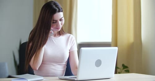 Portrait of Millennial Woman Sitting at Table at Home, Talking on Phone with Salesman Call Center