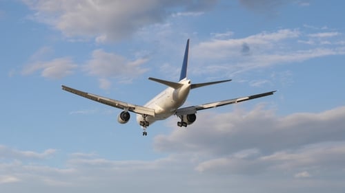 Airplane Is Landing Back View. Plane at Blue Sky Background with Clouds. Airplane Arrive