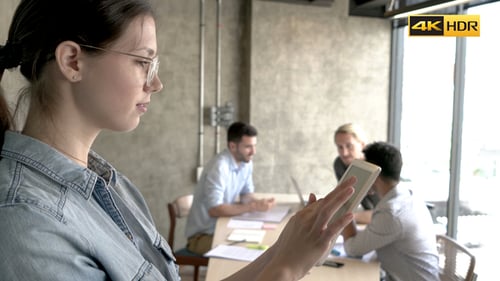 Businesswoman Presents Data Using Tablet to Colleagues