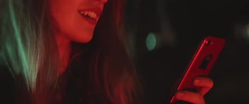 Woman smiles while texting