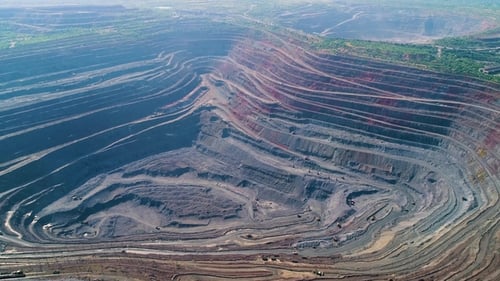 Vista aérea da pedreira de mineração a céu aberto com muitas máquinas no trabalho