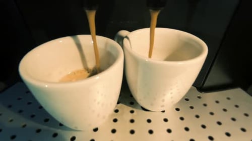 Heimkaffeemaschine macht zwei Espresso-Kaffees, langsam fällt Kaffee